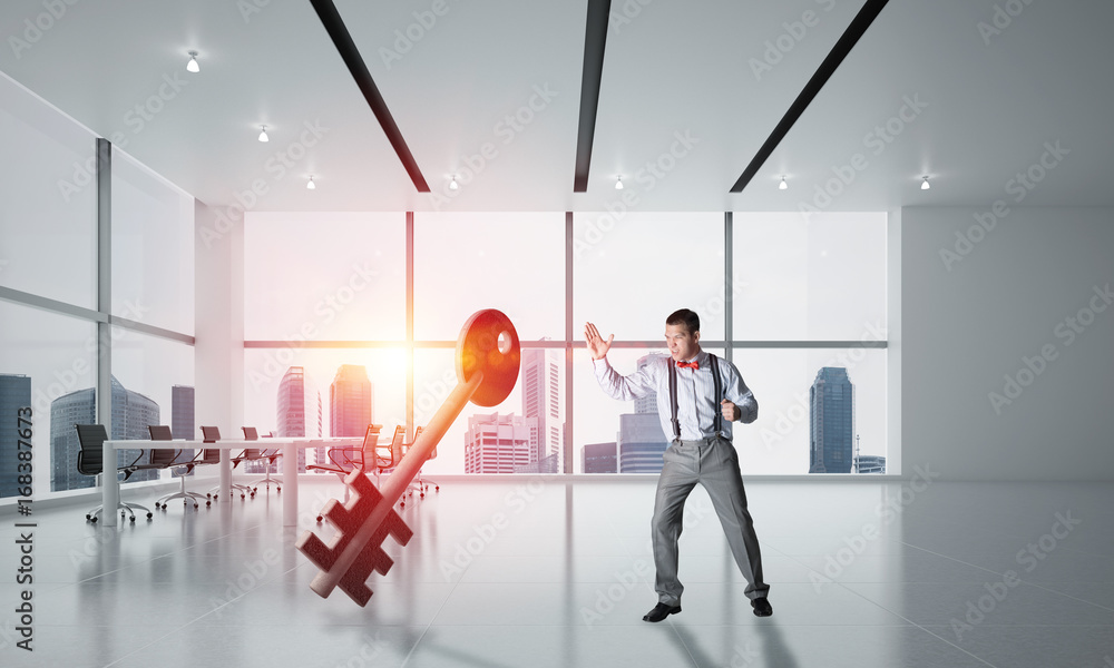 Fototapeta premium Breaking through access concept with furious man crashing concrete key
