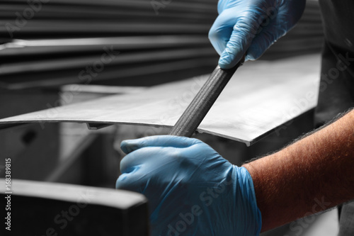 Man filing deburring a metal panel with a file photo