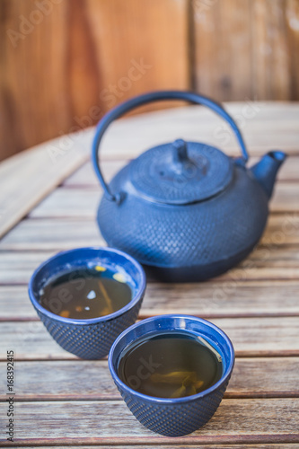 Traditional japanese green tea prepared in cast iron teapot with organic dry green tea.