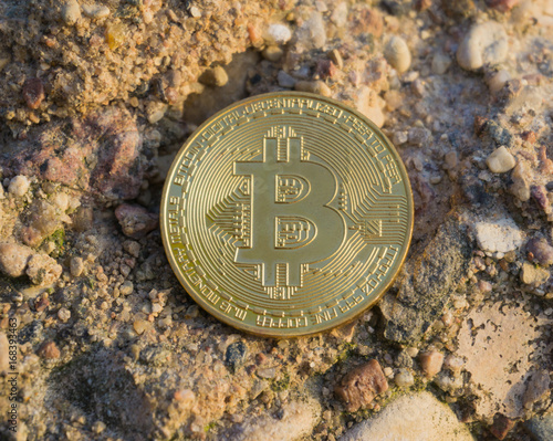 Golden bitcoin on stone surface. Close-up view photo