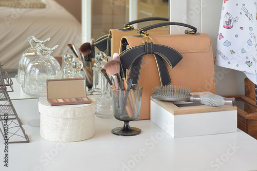 Fotografia Make up items and leather bag on dressing table