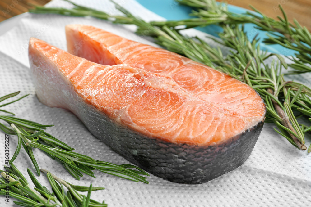 Fresh salmon steak with rosemary on paper towel Fresh salmon steak with rosemary on paper towel