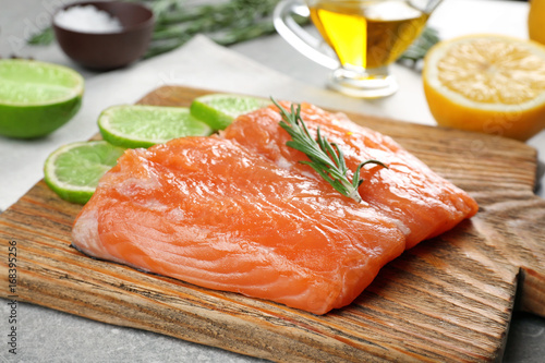Fresh salmon fillet with rosemary and lime on wooden board