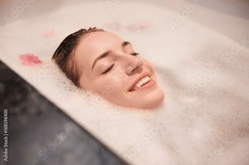 Woman relaxing in bath with...