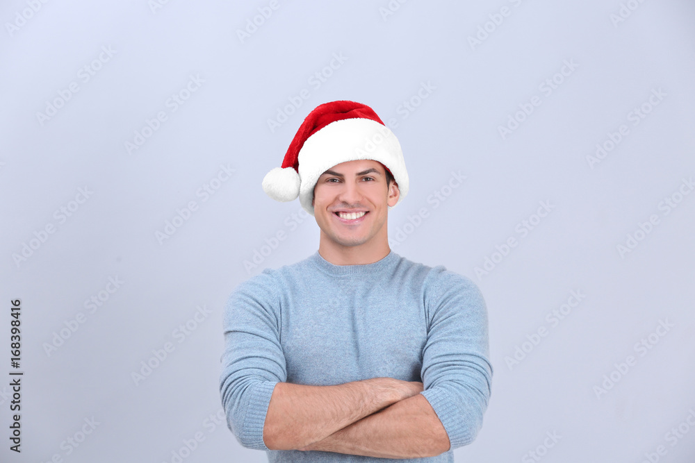 Handsome man in Christmas hat on light background Handsome man in Christmas hat on light background