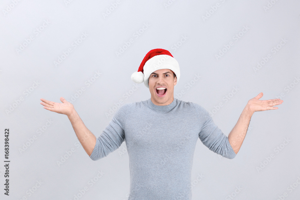 Handsome man in Christmas hat on light background Handsome man in Christmas hat on light background