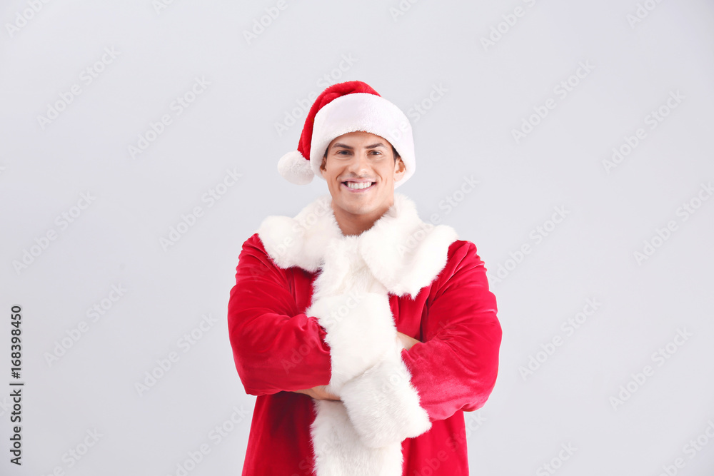Handsome man in Santa Claus costume on light background Handsome man in Santa Claus costume on light background