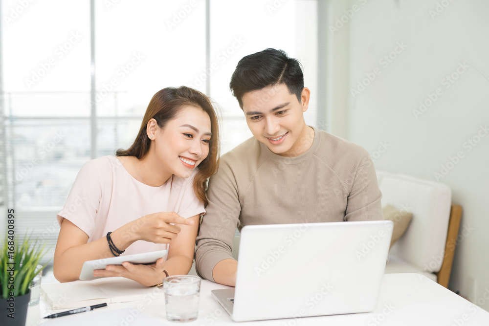 Happy businesswoman and businessman using laptop at workplace in office Happy businesswoman and businessman using laptop at workplace in office
