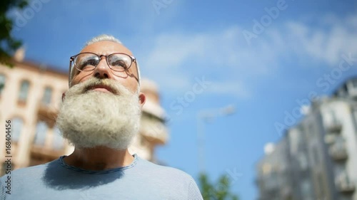Bearded man with glasses promenading in downtown