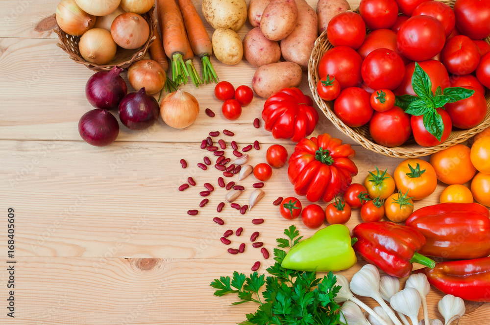 Tomatoes, carrots, potatoes and other fresh vegetables on a wooden table Tomatoes, carrots, potatoes and other fresh vegetables on a wooden table