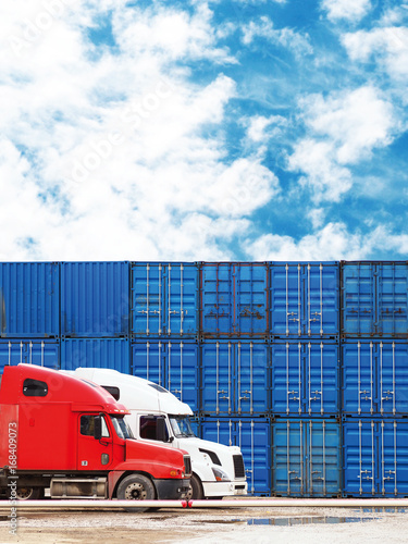 Big trucks on the background of cargo containers. Cargo delivery, logistic, shipping and transportation concept. Blue freight containers on the sky background