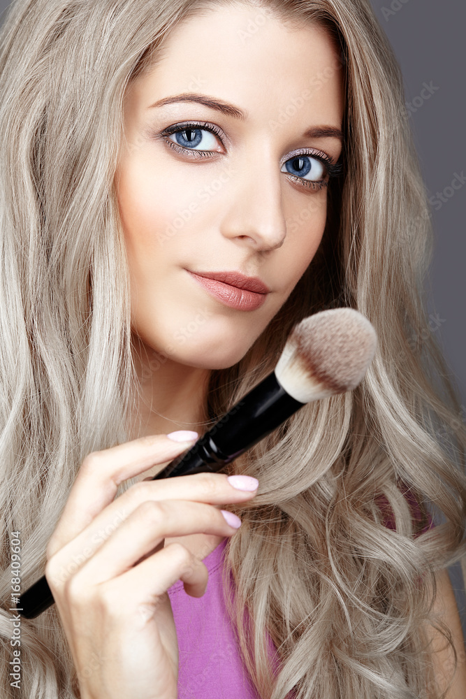 Blonde beauty female stylist - visagist with makeup brushes Blonde beauty female stylist - visagist with makeup brushes