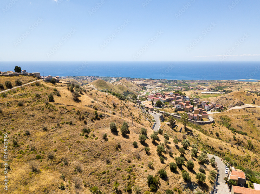 Vista aerea di colline e colli dell’entroterra della Calabria, con vista sul mar Ionio. Italia