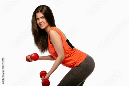 Beautiful young sporty fitness woman with dumbbells
