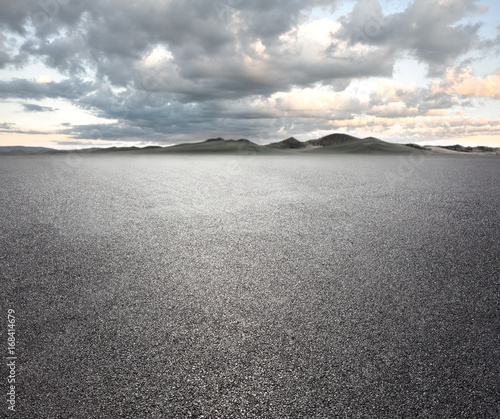 Asphalt road with cloudy sky and mountain background