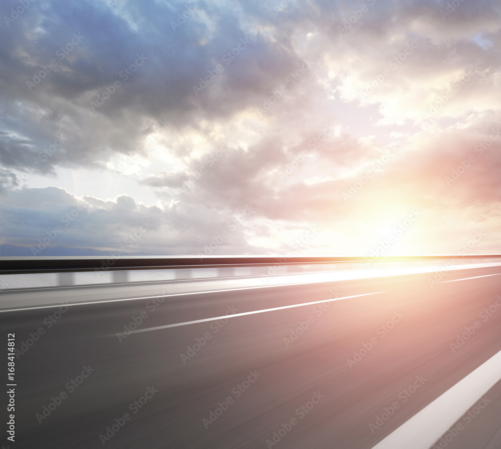 Asphalt road with cloudy sky and mountain background.