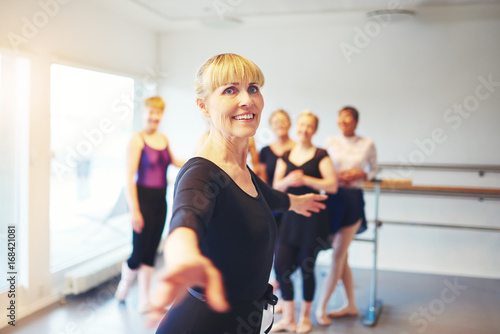Smiling senior woman practicing ballet in a dance studio