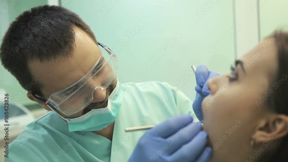 Doctor doing dental treatment to his patient in clinic Doctor doing dental treatment to his patient in clinic