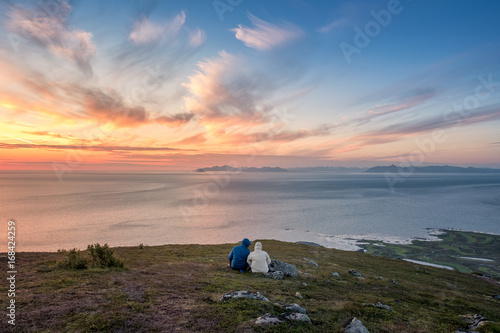 Couple enjoy sunset at summer night in top of the mountain Lofoten, Norway