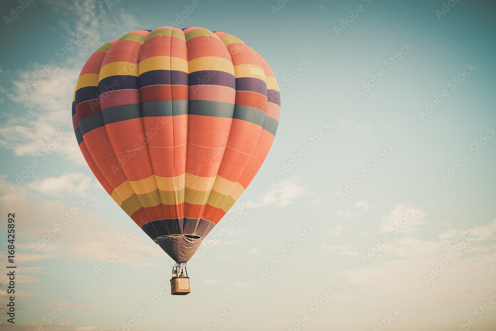 Fototapeta premium Vintage hot air balloon flying on sky. travel and air transportation concept -vintage and retro filter effect style