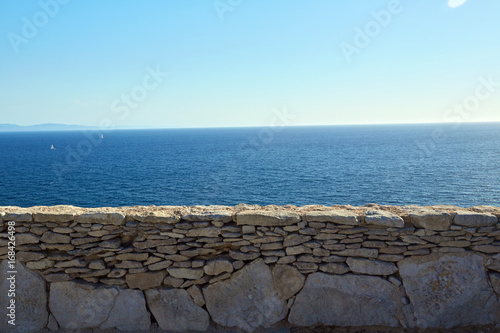 Muretto di pietre con mare sullo sfondo photo