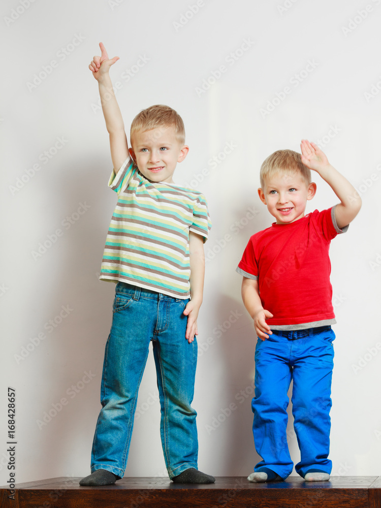 Two little boys siblings playing together on table Two little boys siblings playing together on table