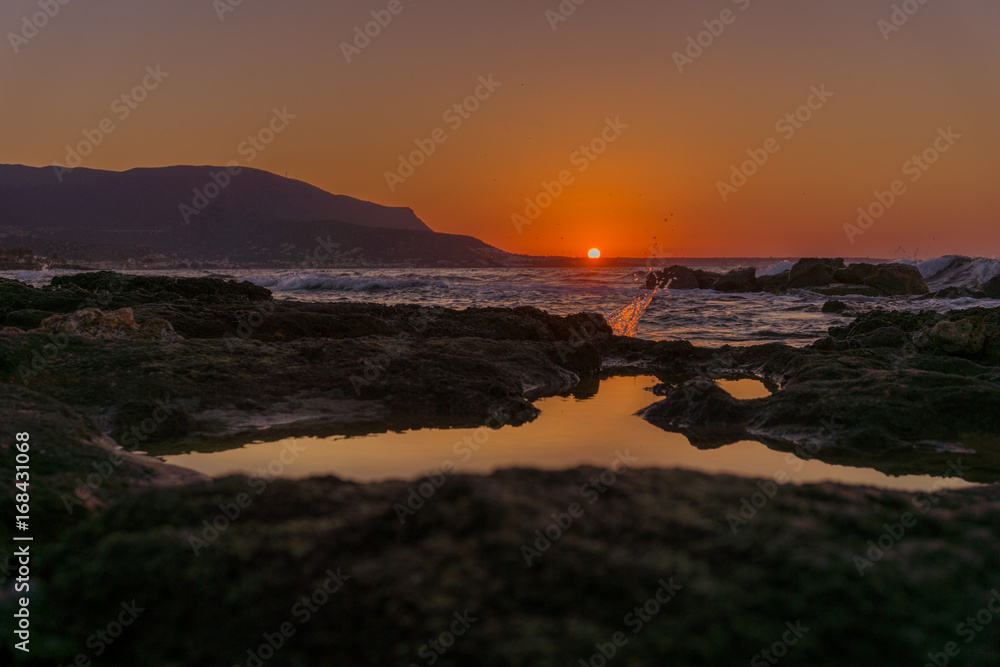 Blick auf Sonnenuntergang und Felsen im Meer