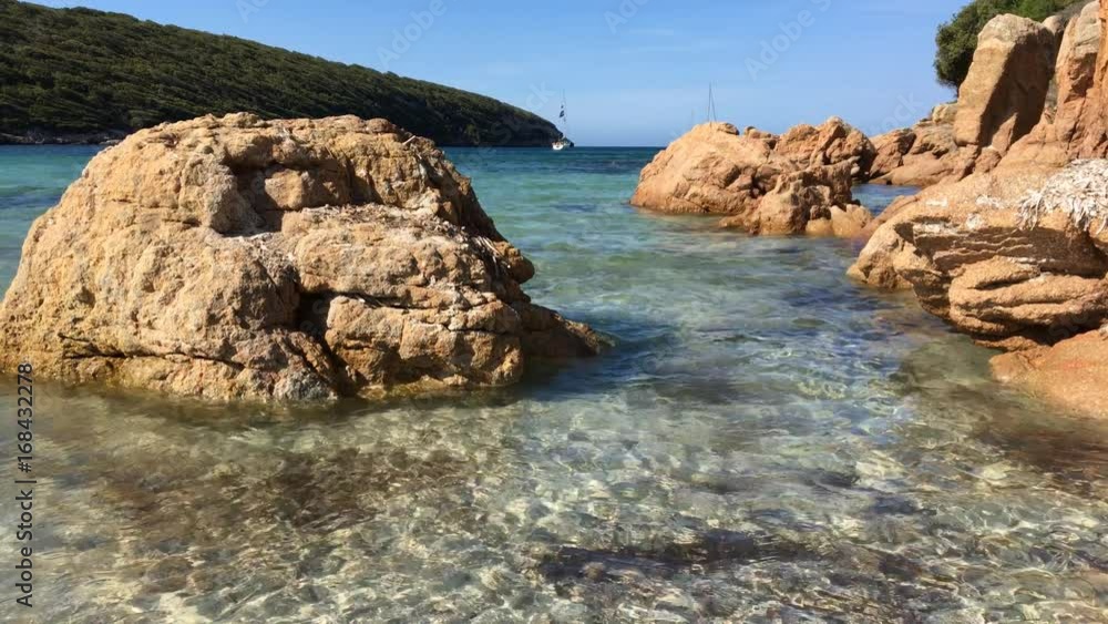 Spiaggia di Paraguan con acqua cristallina e rocce a rosse a picco Spiaggia di Paraguan con acqua cristallina e rocce a rosse a picco