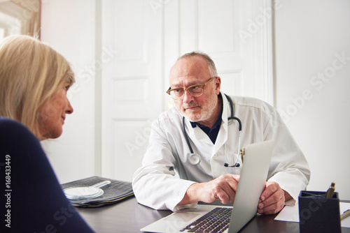 Medic explaining diagnosis to woman pointing at laptop © Flamingo Images