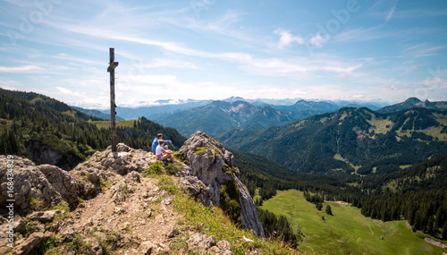 Hiker on mountain top peak viewing the alp panorama in Bavaria 