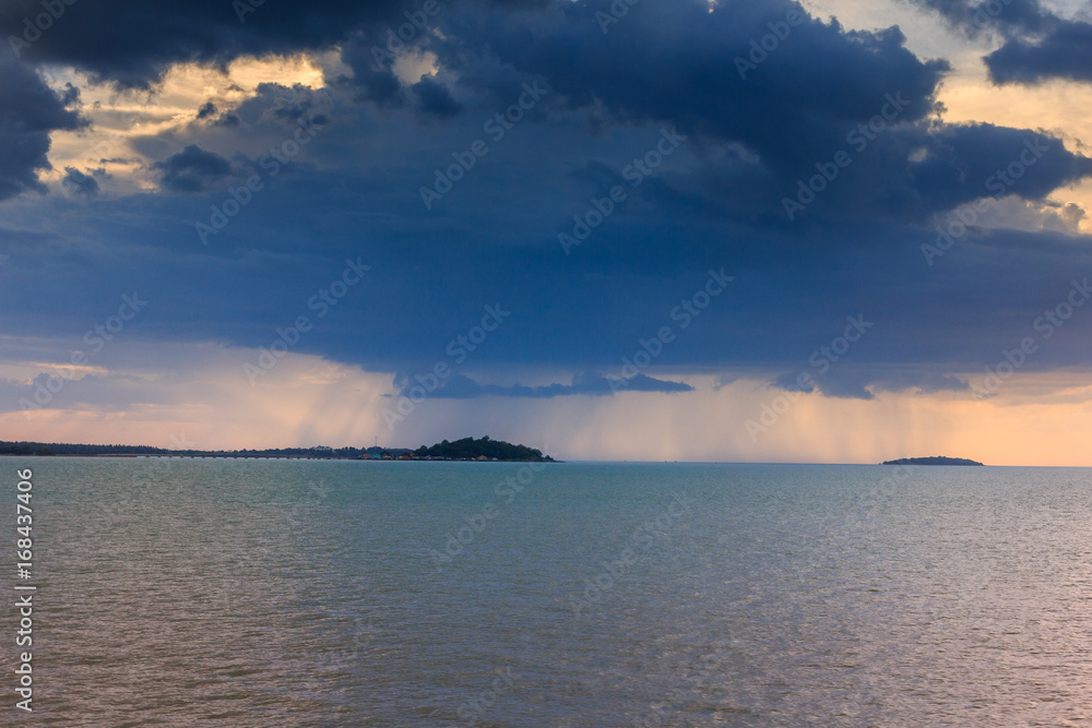 Obraz premium Rain is falling at sunset in the sea.