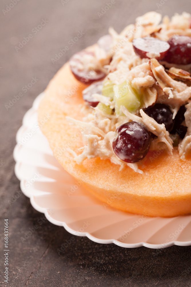 Cantaloupe ring filled with chicken grape cantaloupe salad on a white plate and dark wooden background macro shot
Cantaloupe ring filled with chicken grape cantaloupe salad on a white plate and dark wooden background macro shot