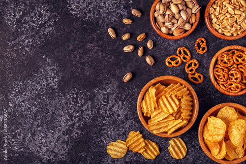 Snacks in a bowls on stone background.