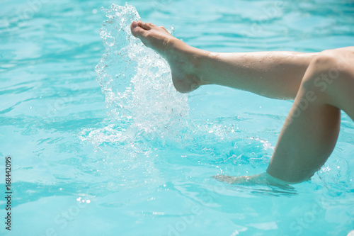 Cropped shot of a woman's legs in the water of swimming pool