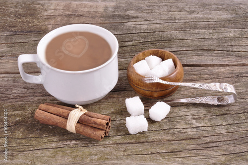 White mug with instant coffee and sugar bowl on an old wooden table