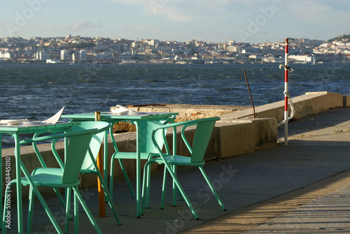 Turquoise table and chairs by Tagus river in Lisbon