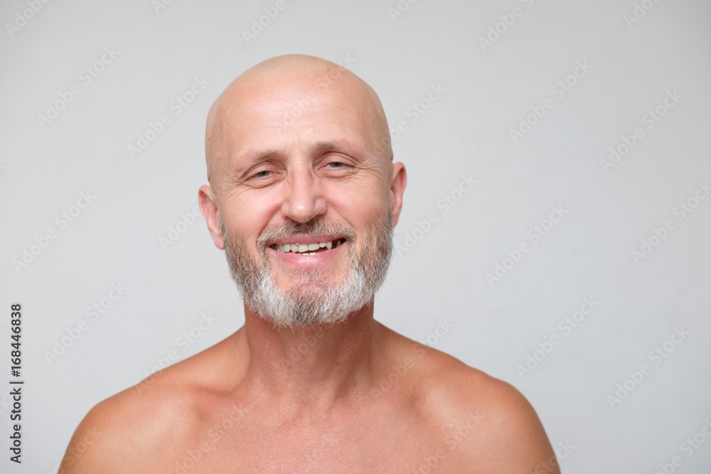 Obraz premium portrait of adult bearded bold skinhead grizzled man on gray