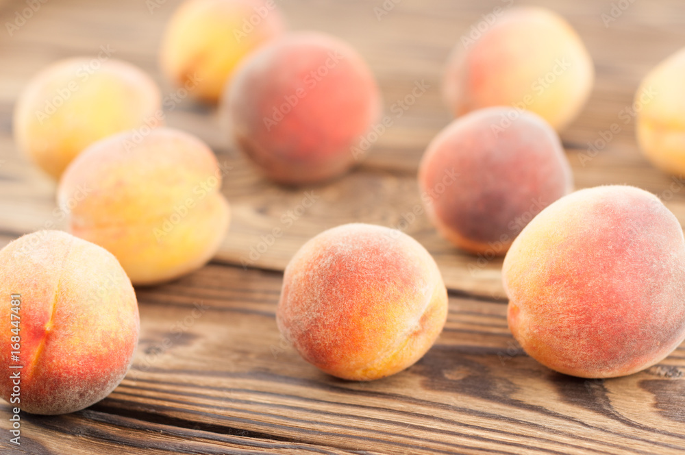 Many scattered fresh whole ripe peaches on old rustic wooden planks Many scattered fresh whole ripe peaches on old rustic wooden planks