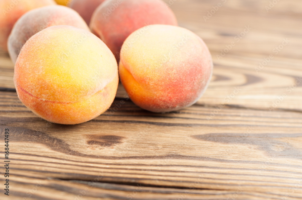 Row of fresh whole ripe peaches on old rustic wooden planks Row of fresh whole ripe peaches on old rustic wooden planks