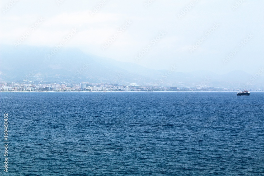 Quiet sea surface and city landscape in the distance (Alanya, Turkey).