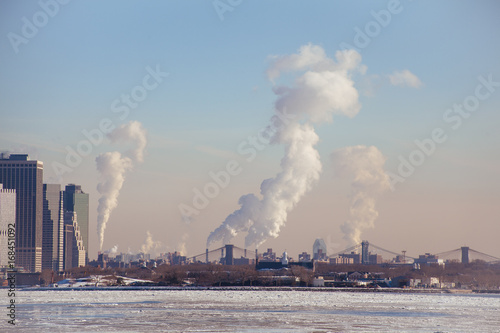 Climate change. Tip of Lower Manhattan, Brooklyn Bridge, Manhattan Bridge. Industrial Steam smoke rising. 