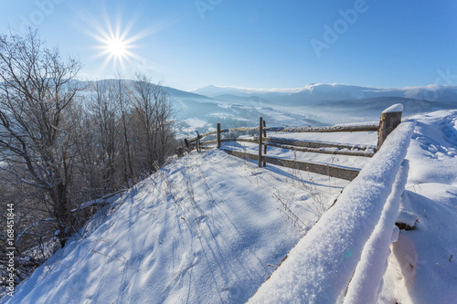 Winter country landscape with timber fence and snowy road © Ryzhkov Oleksandr