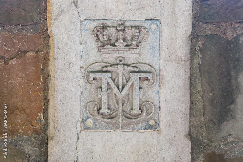 Initials of Mexican Emperor Maximilian and symbols on a stone wall at castle Miramare, Trieste