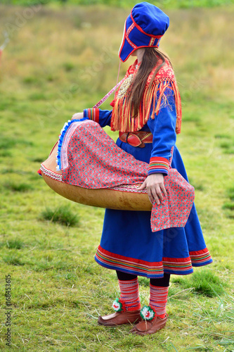 Northern Norway, a traditional dressed Sami woman with a cradle