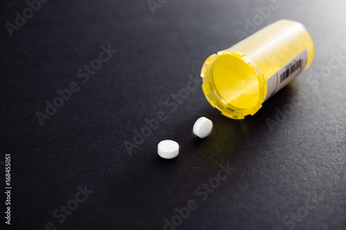 Yellow pill bottle and prescription medication. 
