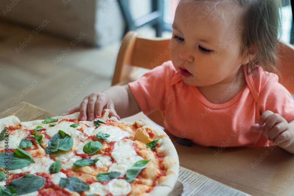 baby girl eating pizza in italian restaurant, Healthy, unhealthy food, children's fast food baby girl eating pizza in italian restaurant, Healthy, unhealthy food, children's fast food