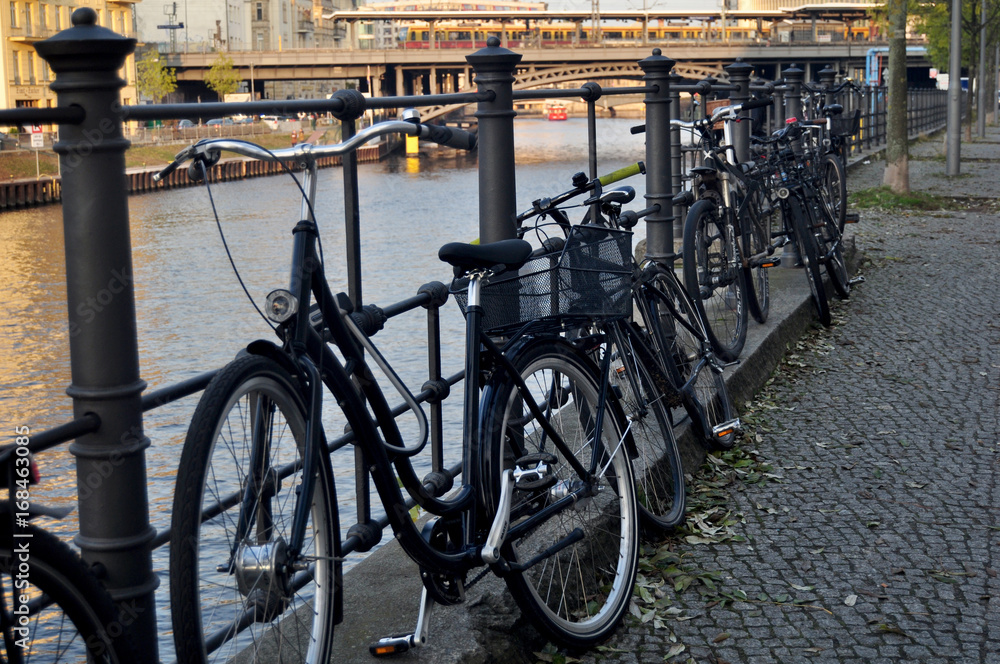 Bicycle parking at people stop and lock bike at riverside of Spree river at Berlin city