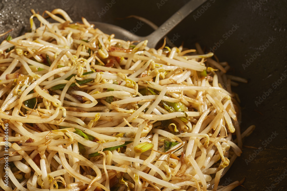 stir fried bean sprouts and scallions in a black steel wok