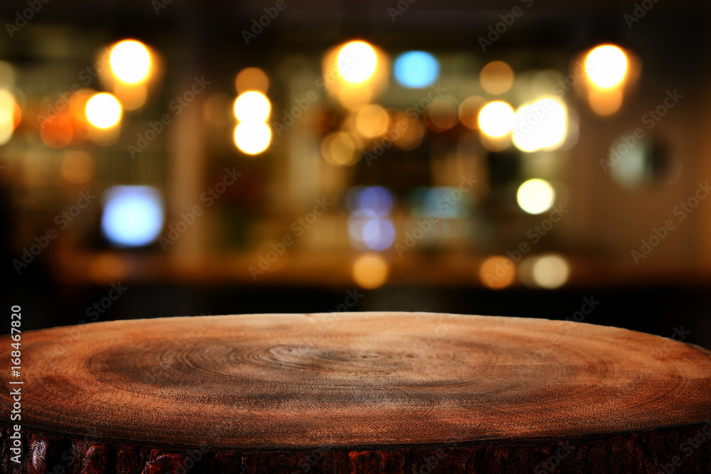 Image of wooden table in front of abstract blurred restaurant lights background - obrazy, fototapety, plakaty 