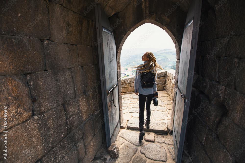 Woman with the camera explores a medieval castle fortress.